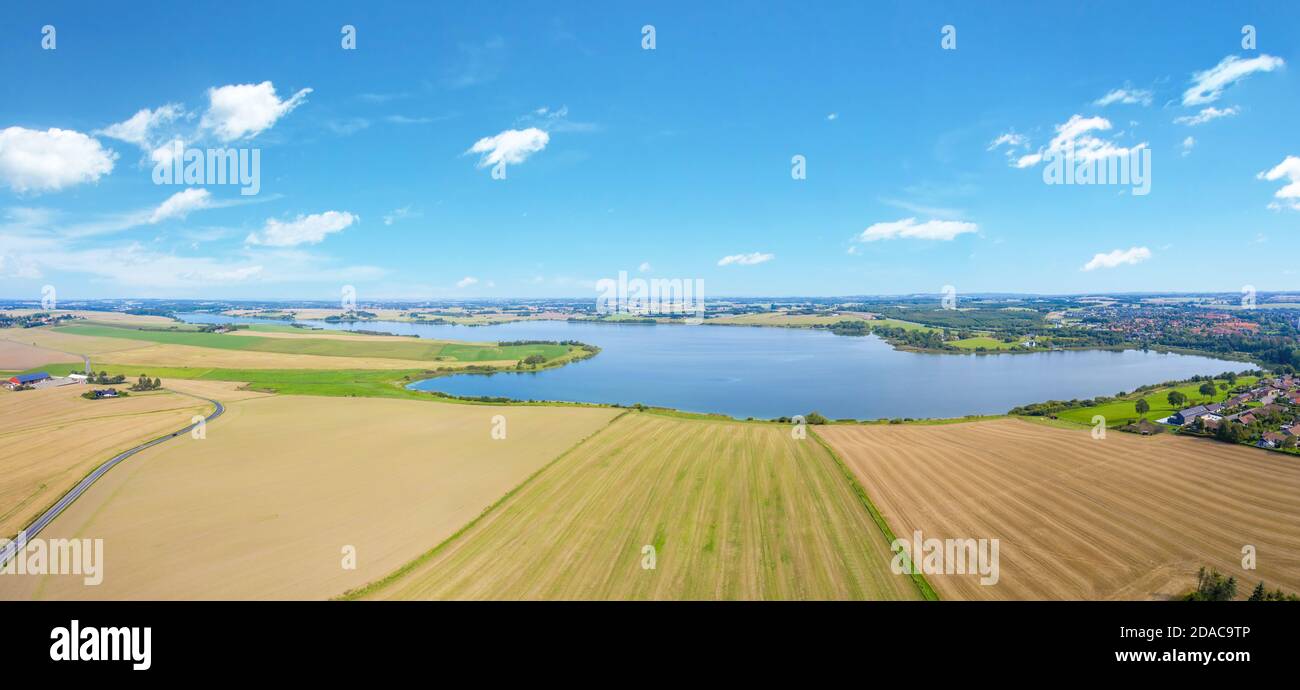 Title: A drone view of the lake in Skanderborg, Denmark. It has a total surface area of 8.6 square kilometers and an average depth of 8 meters. Stock Photo