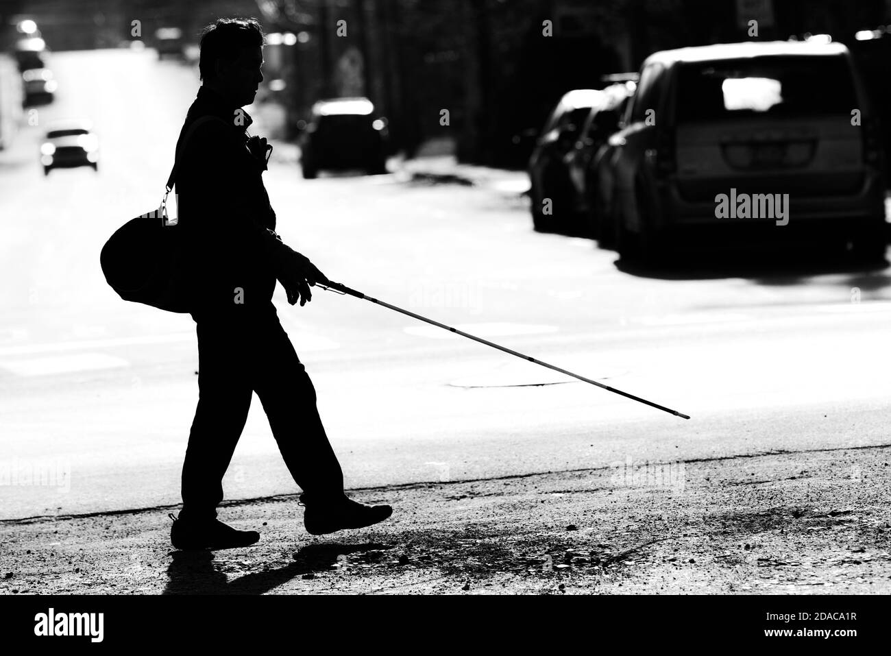 Silhouette of visually impaired man walking with white cane, Montpelier