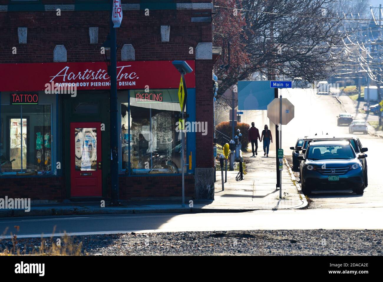 Couple strolling hand in hand near tattoo parlor Montpelier, capital of Vermont, USA. Stock Photo