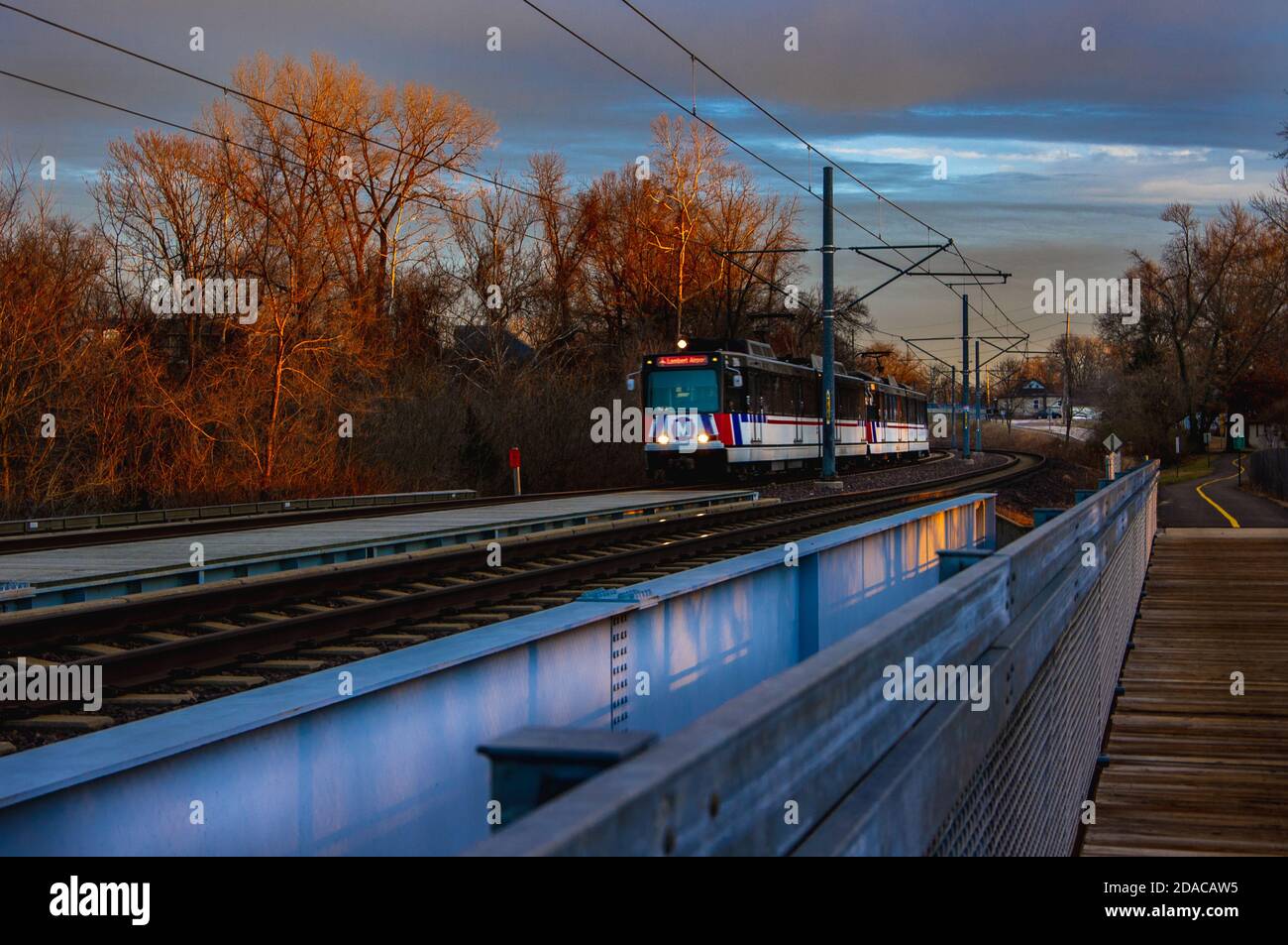 Belleville, IL--Jan 8, 2019; Saint Louis metro light rail train crossing bridge at sunset Stock Photo