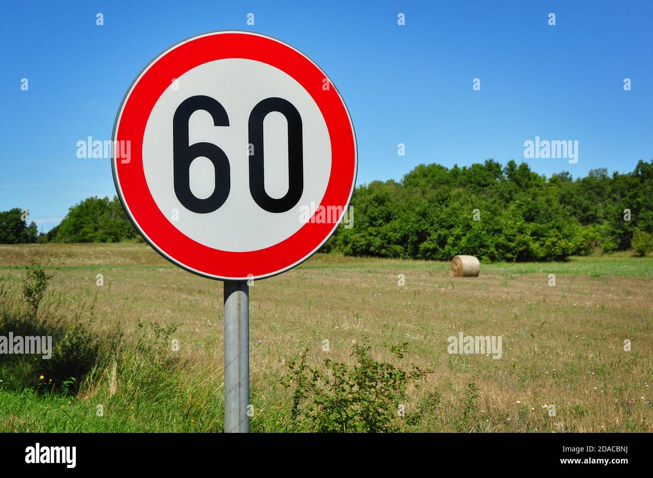 Speed limit traffic sign 60 kmph in the countryside, on a sunny summer day,  Istria, Croatia Stock Photo