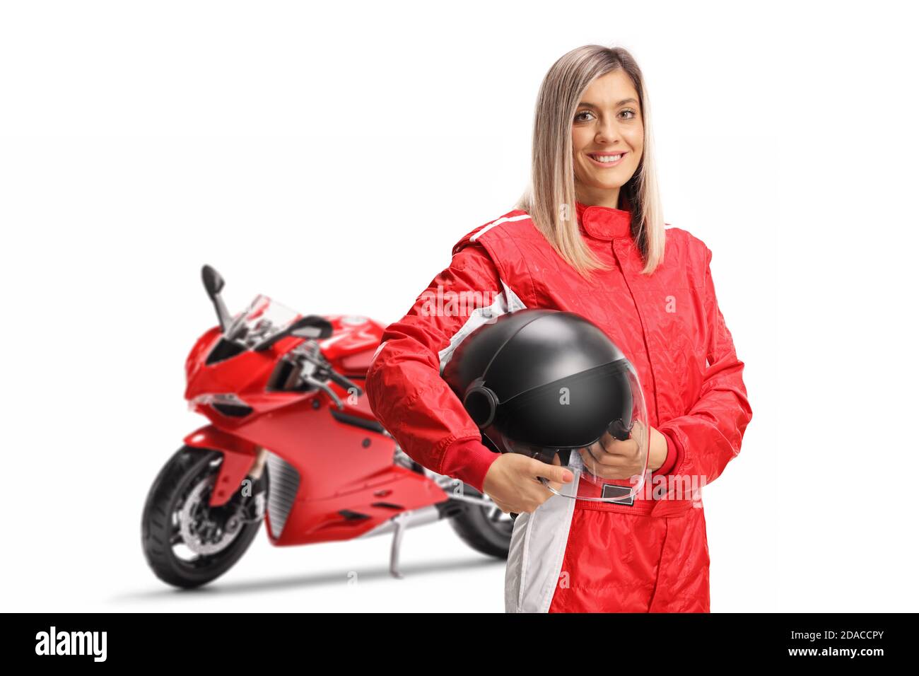 Smiling female motorbike racer in a red suit holding a helmet isolated on white background Stock Photo