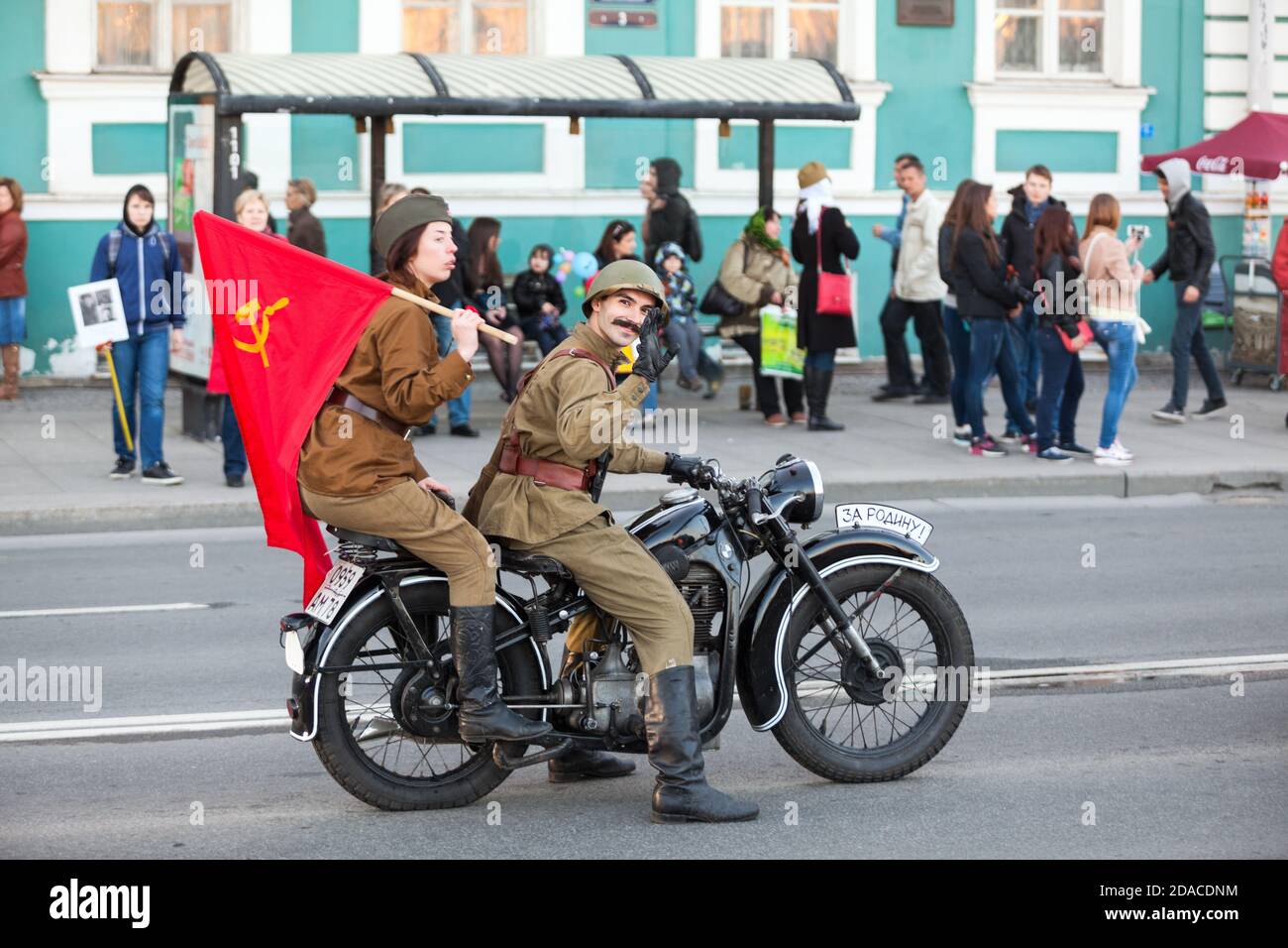 SAINT-PETERSBURG, RUSSIA-MAY 9, 2015: Man and woman dressed soviet uniform ride on vintage motorcycle in center of city. Celebration of the 70 anivers Stock Photo