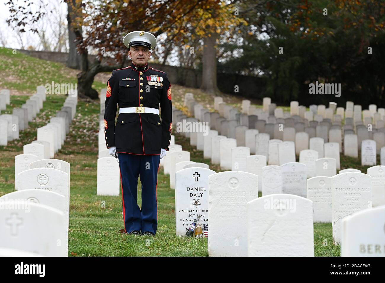 Former US Marine Albert Grajales stands at attention beside the headstone of honored United States Marine Daniel Dal (1837-1937), at Cypress Hills National Cemetery in the Brooklyn borough of New York, NY, on November 11, 2020. Mr. Grajales who also served in the Army and in the Air Force reserves, makes an annual pilgrimage to Cypress Hills National Cemetery on Veterans Day in memory of those lost in combat; United States Marine Daniel Daly is one of only two Marines to have received the Medal of Honor twice for two different actions. (Anthony Behar/Sipa USA) Stock Photo