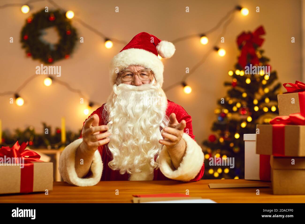 Senior Santa gesticulating during chatting and congratulating people online Stock Photo