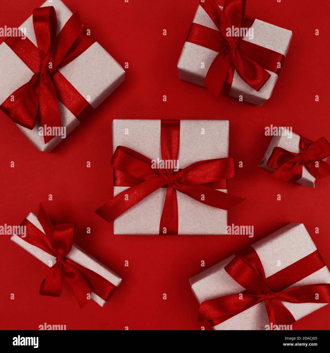 Gift boxes wrapped in craft paper with red ribbons and bows. Festive ...
