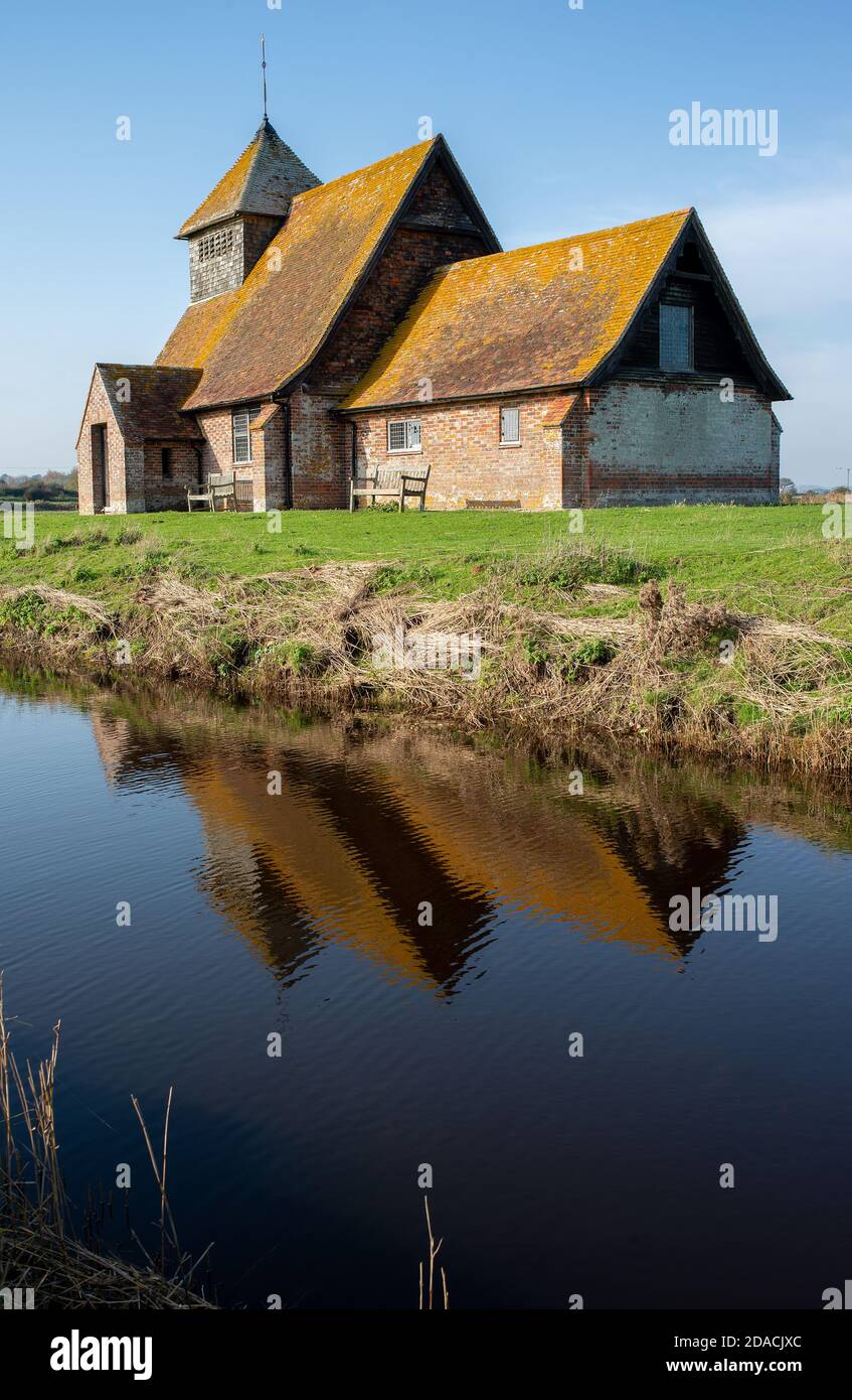 St. Thomas Becket church on a bright sunny afternoon, is an English 13th century church which sits isolated on marshland at Fairfield, Kent, England. Stock Photo