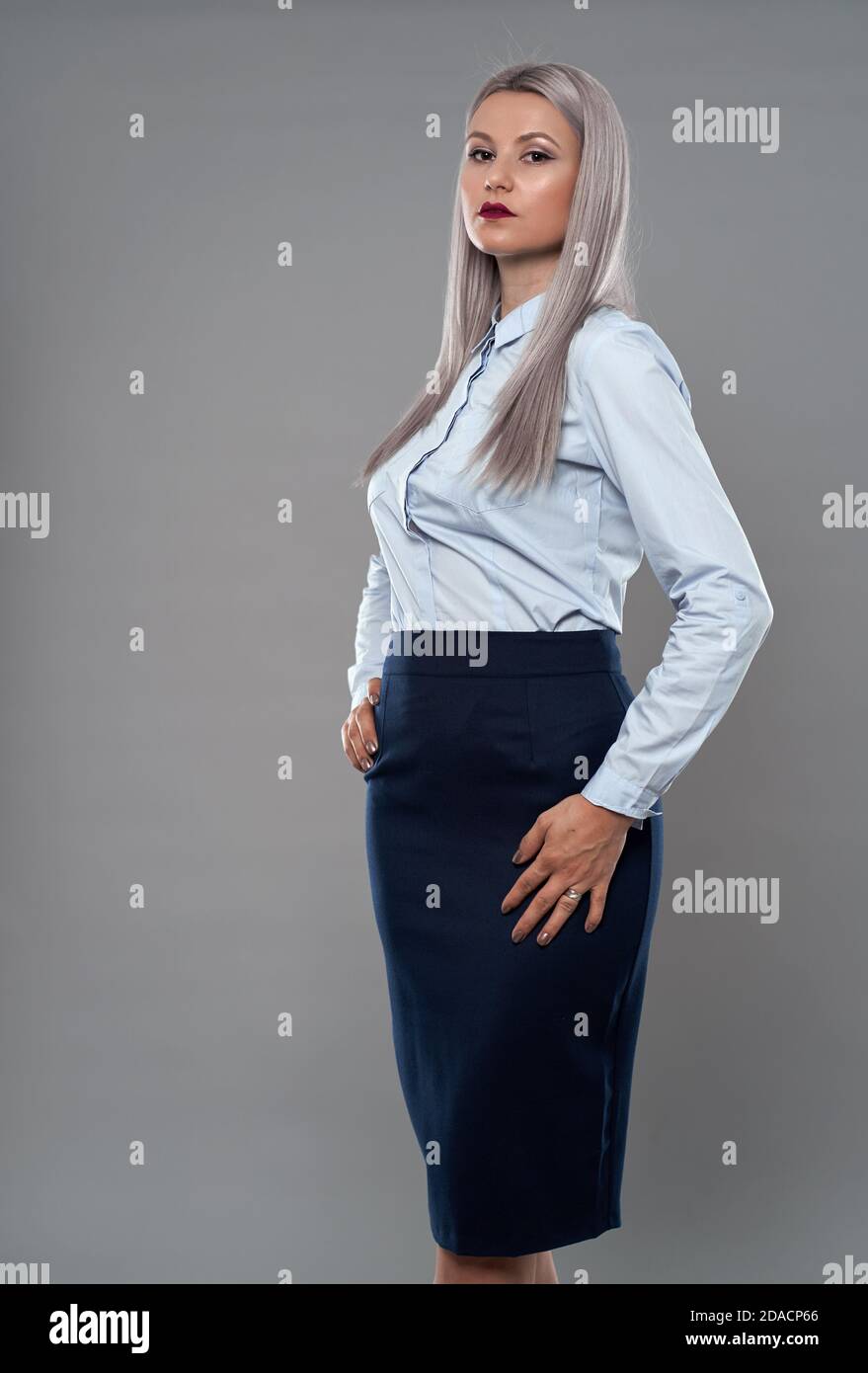Young successful businesswoman with hands on hips in business suit Stock Photo