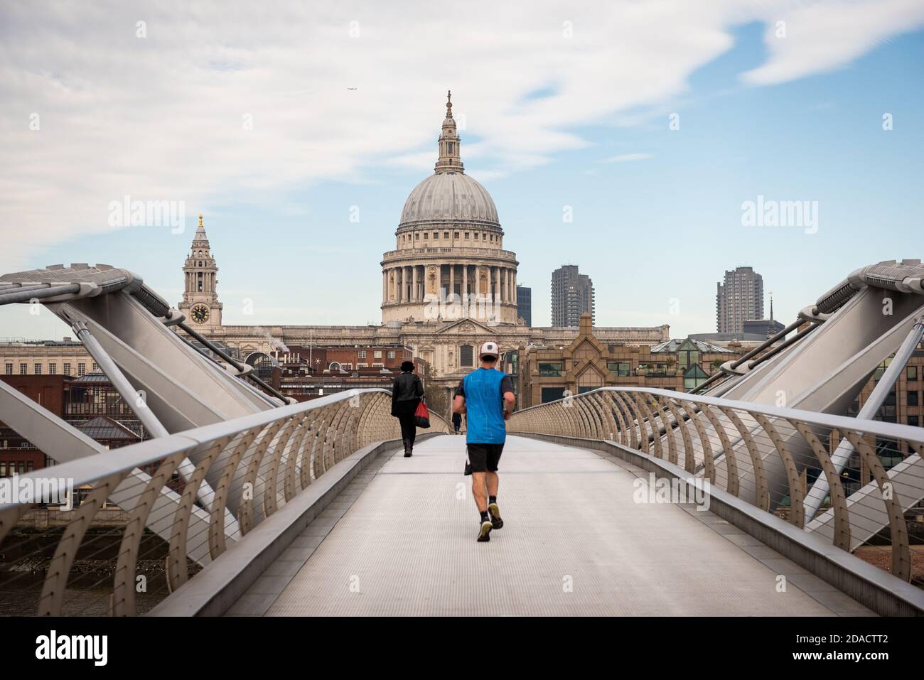 St Pauls Cathedral looking over the mellenium bridge with someone jogging with back to us Stock Photo