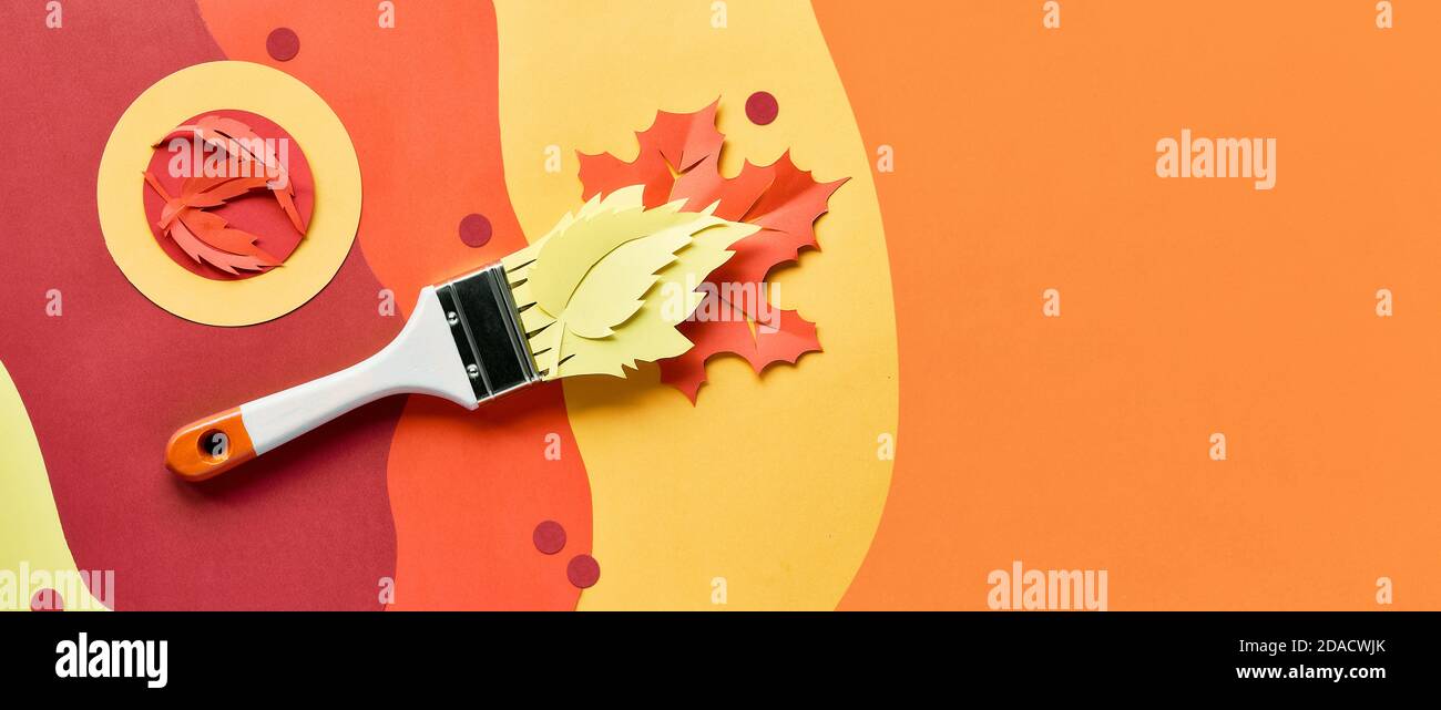 Brush loaded with paint made of paper Autumn leaves. Home renovation panoramic background, top view. Stock Photo