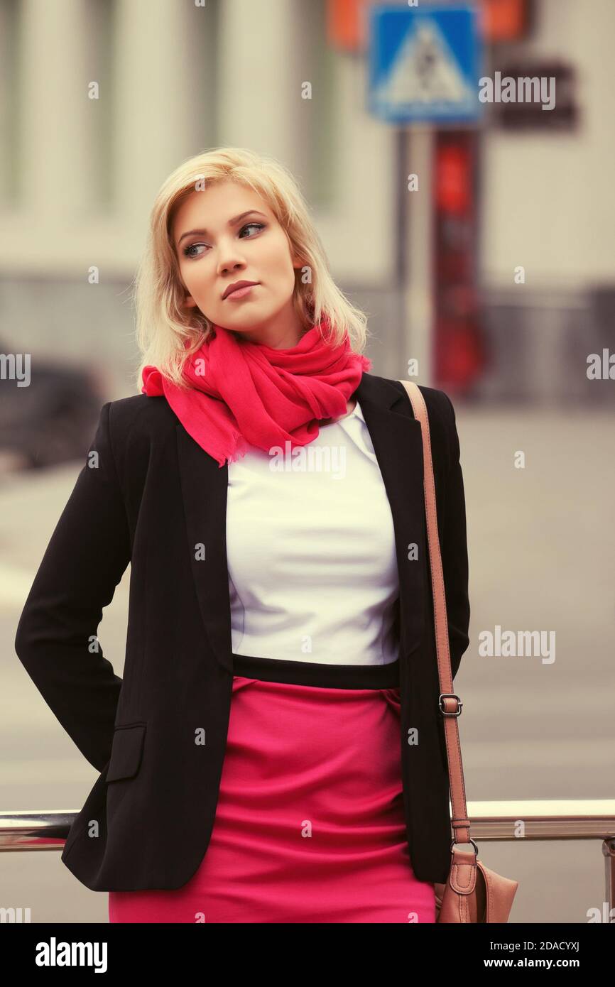 Young fashion business woman walking in city street. Stylish female model in black jacket outdoor Stock Photo