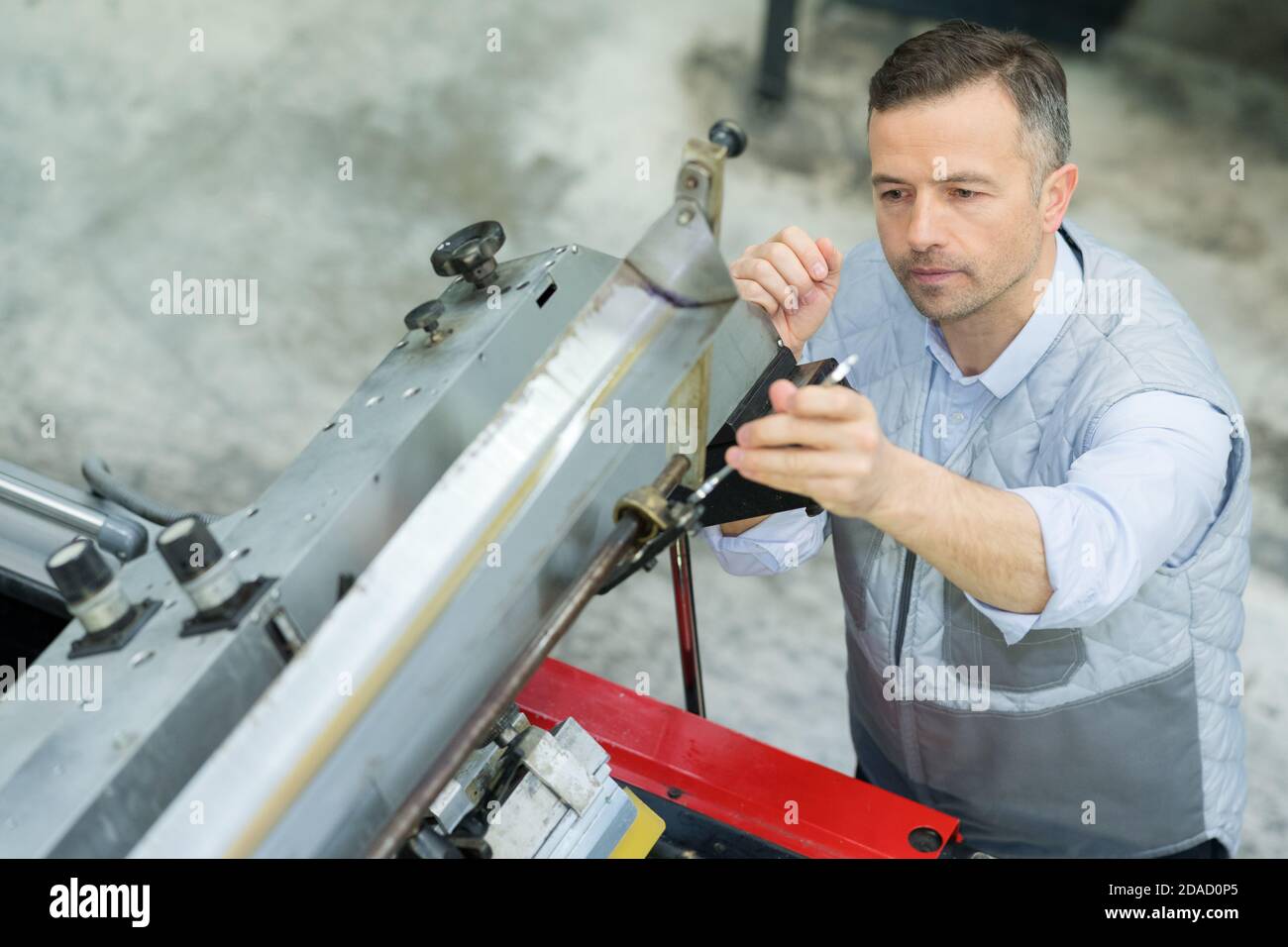 worker checking a printing machine Stock Photo Alamy