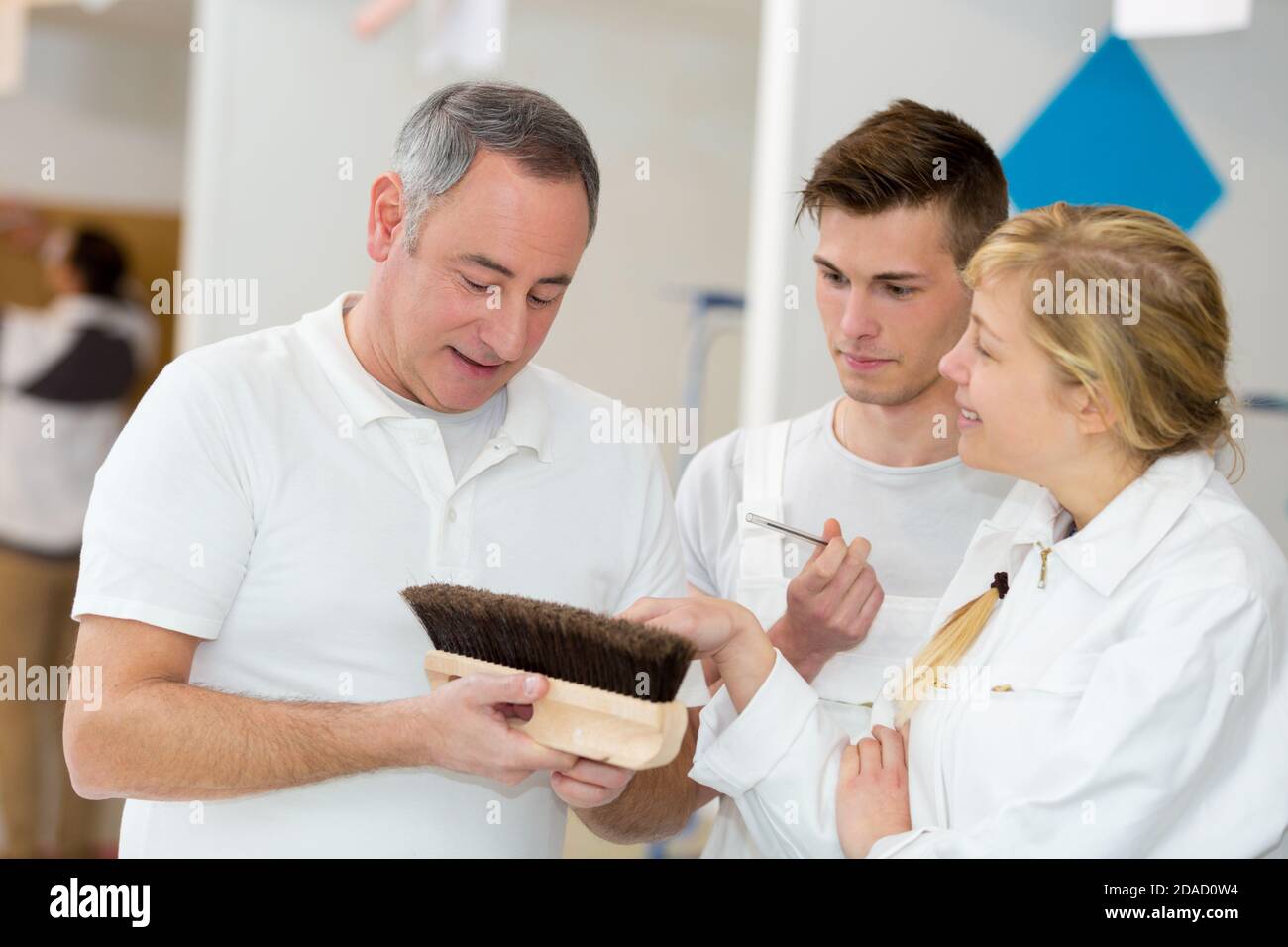 apprentices learning how to paint with a thick brush Stock Photo