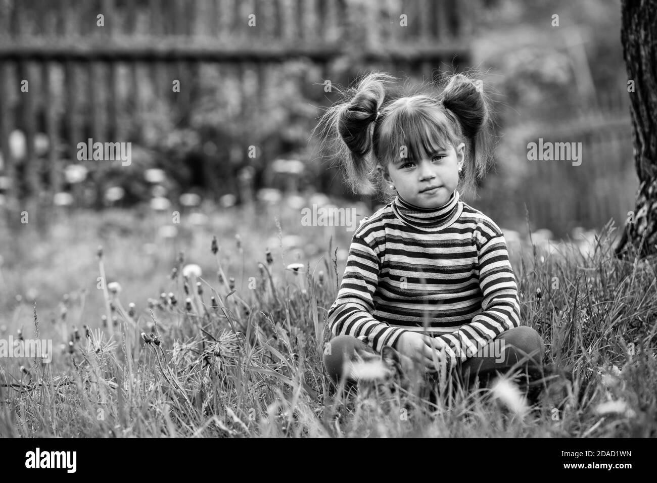 Lovely little girl playing in the park. Black and white photography. Stock Photo