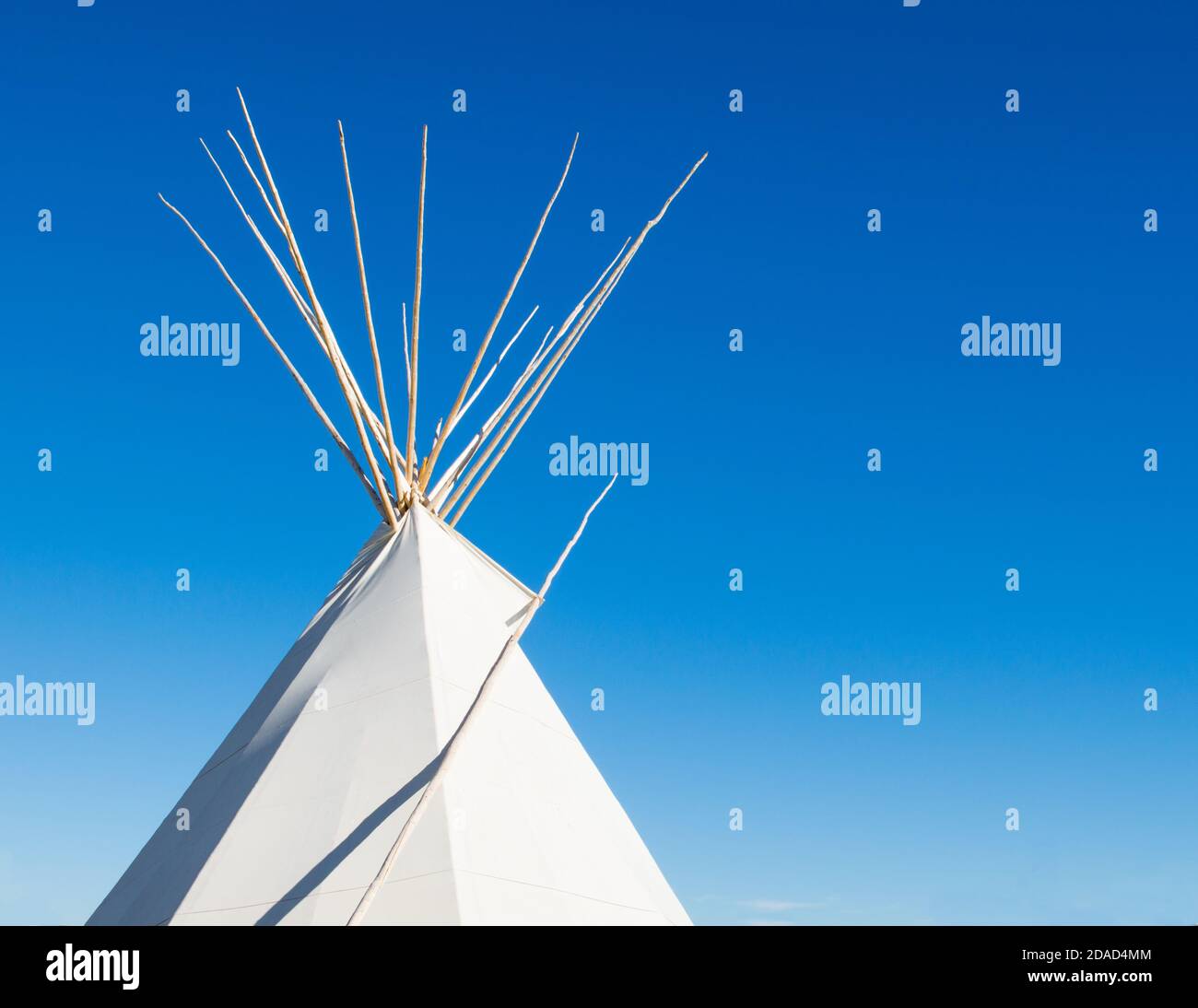 a Native American tipi against a bright blue sky with copy space Stock Photo