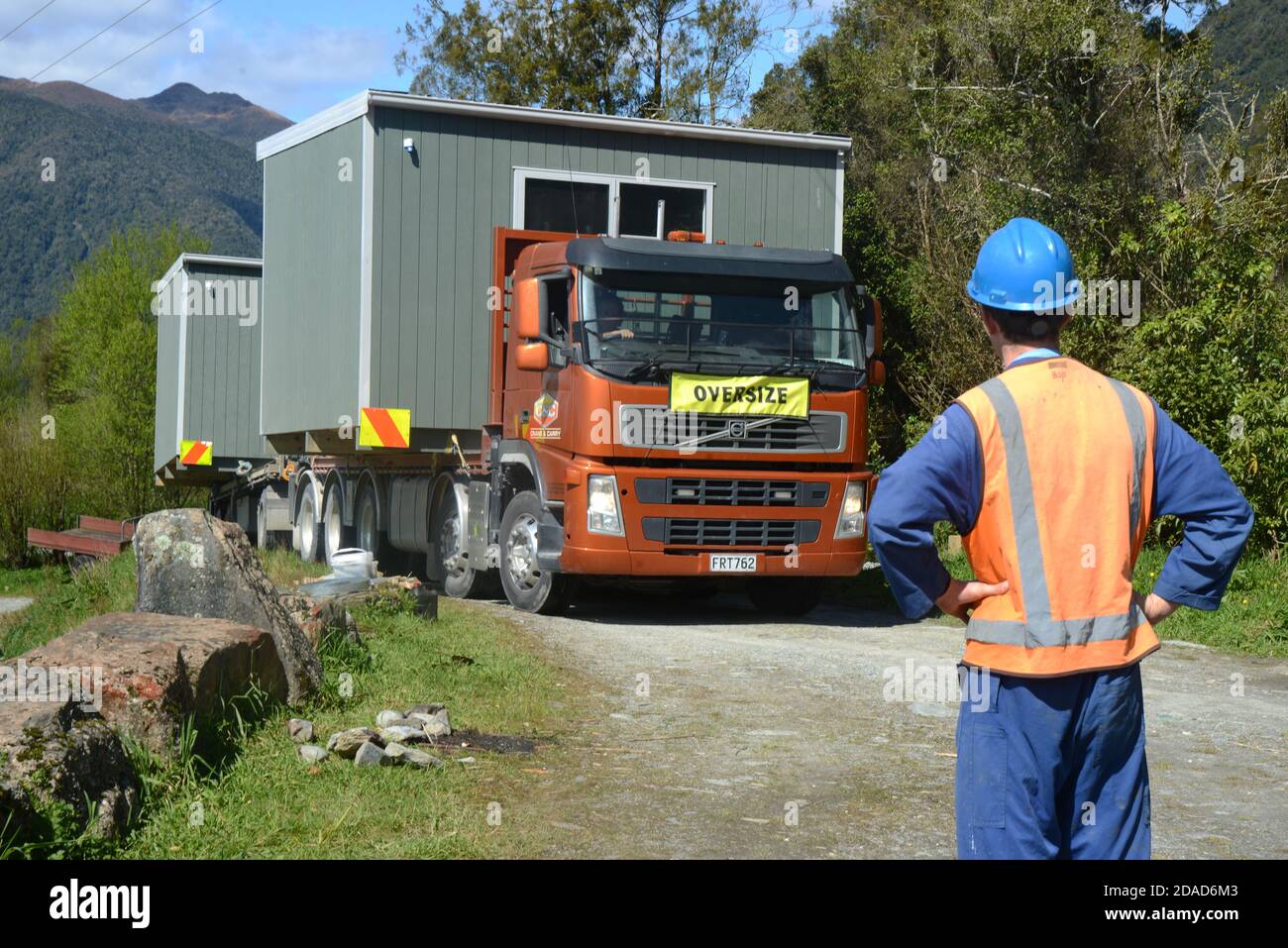GREYMOUTH, NEW ZEALAND, OCTOBER 21, 2020: A construction worker awaits the arrival of a crane operator who will lift a small building from a truck ont Stock Photo