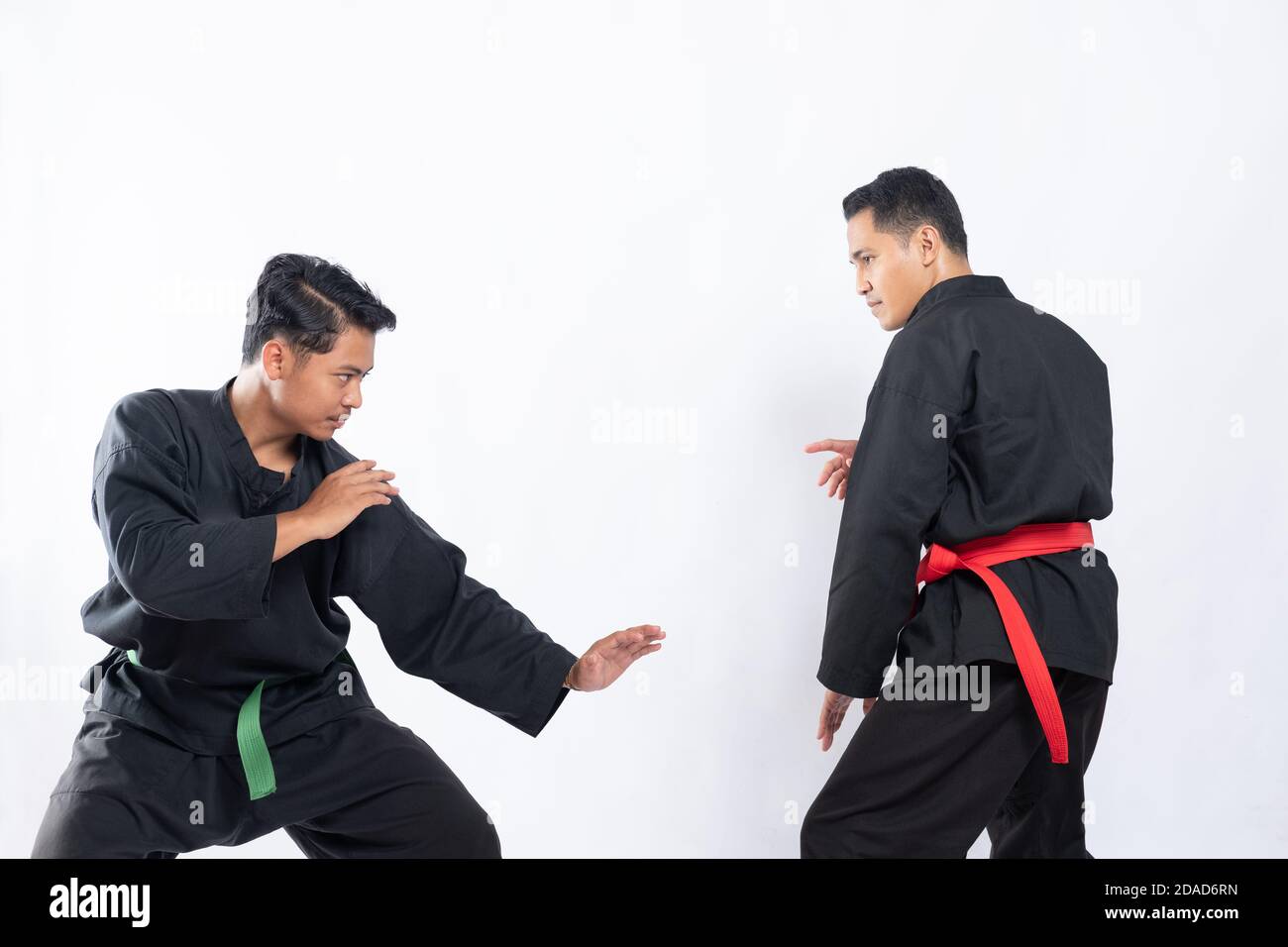 two fighters in pencak silat Hitam uniform fight in low stance and side