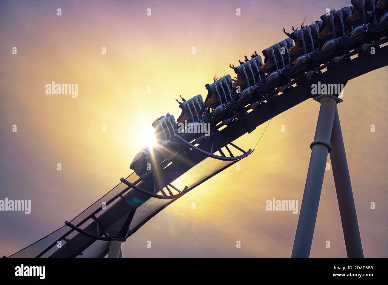 Funny people riding roller coaster with sun light Stock Photo