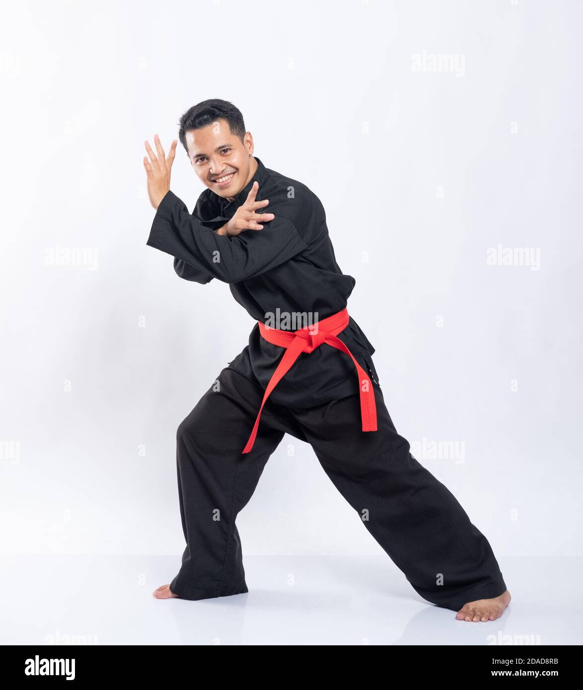 Asian men wearing pencak silat uniforms with red belts do dodging ...