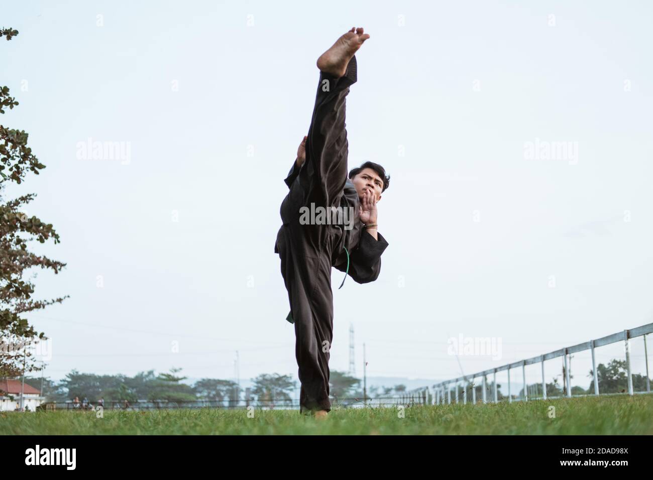 Asian male fighter wearing a pencak silat uniform performs a straight ...