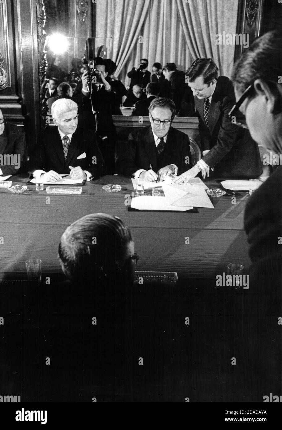 In this photo released by the White House, Dr. Henry A. Kissinger, background, center, initials the cease fire agreement in Paris, France on Tuesday, January 23, 1973. at the International Conference Center in Paris, France on Tuesday, January 23, 1973. Mandatory Credit: Robert L. Knudsen/White House via CNP | usage worldwide Stock Photo