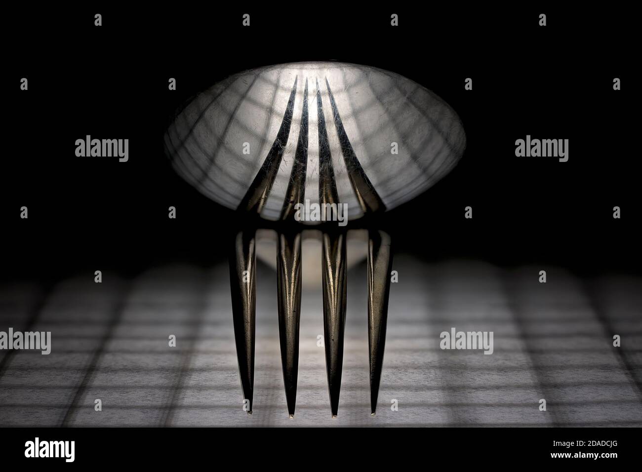 Spoon Grid A spoon sitting on top of a fork reflecting the grid pattern below ...