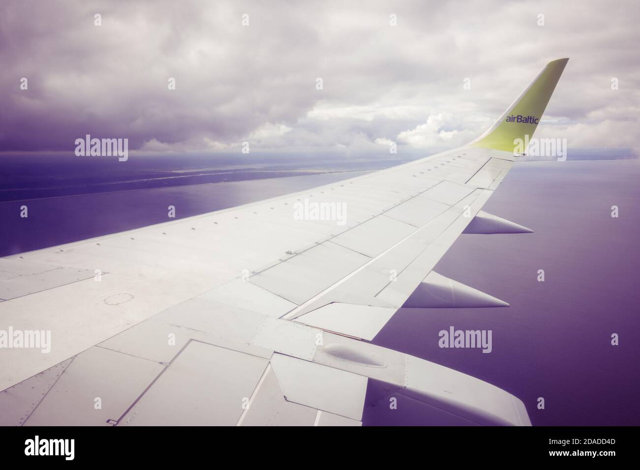 Berlin, Germany - October 01, 2019: Airplane airBaltic in flight - view of an airplane wing in the clouds Stock Photo