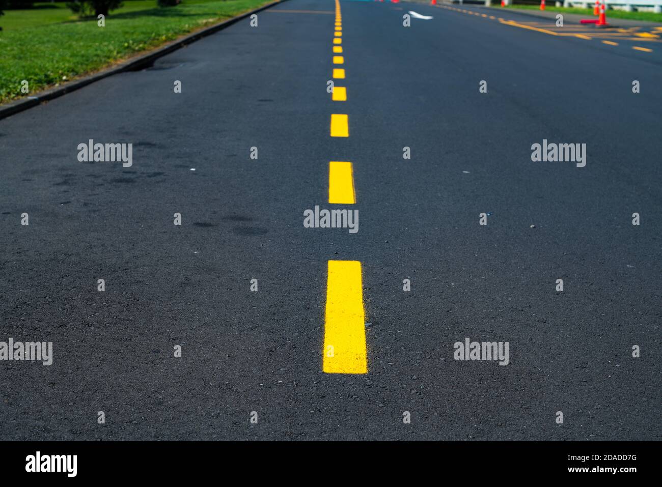 Close-up on a yellow dividing strip on an asphalt road  Stock Photo