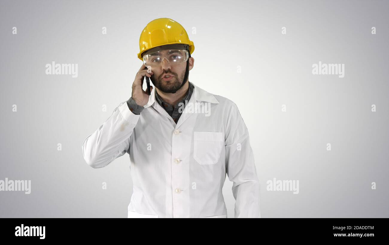 Engineer in protective glasses and hat walking, taking on the ph Stock Photo