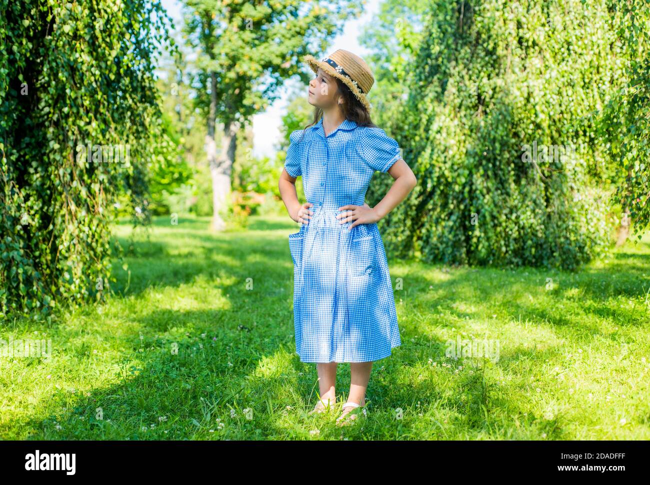 Small kid wear stylish sun hat and checked blue dress on sunny summer  landscape, style Stock Photo - Alamy