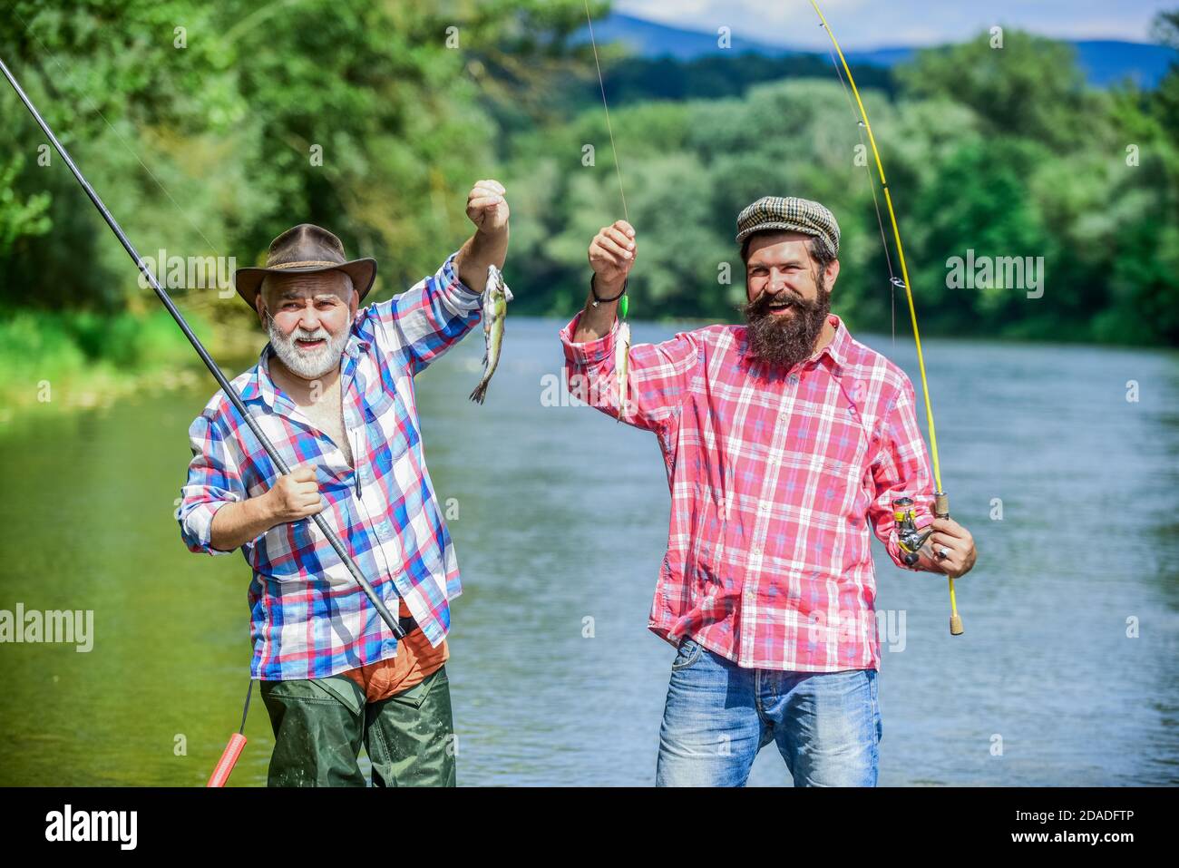 Mature man with friend fishing. Summer vacation. Happy cheerful people.  Fishing freshwater lake pond river. Bearded men catching fish. Family time.  Fisherman with fishing rod. Activity and hobby Stock Photo - Alamy