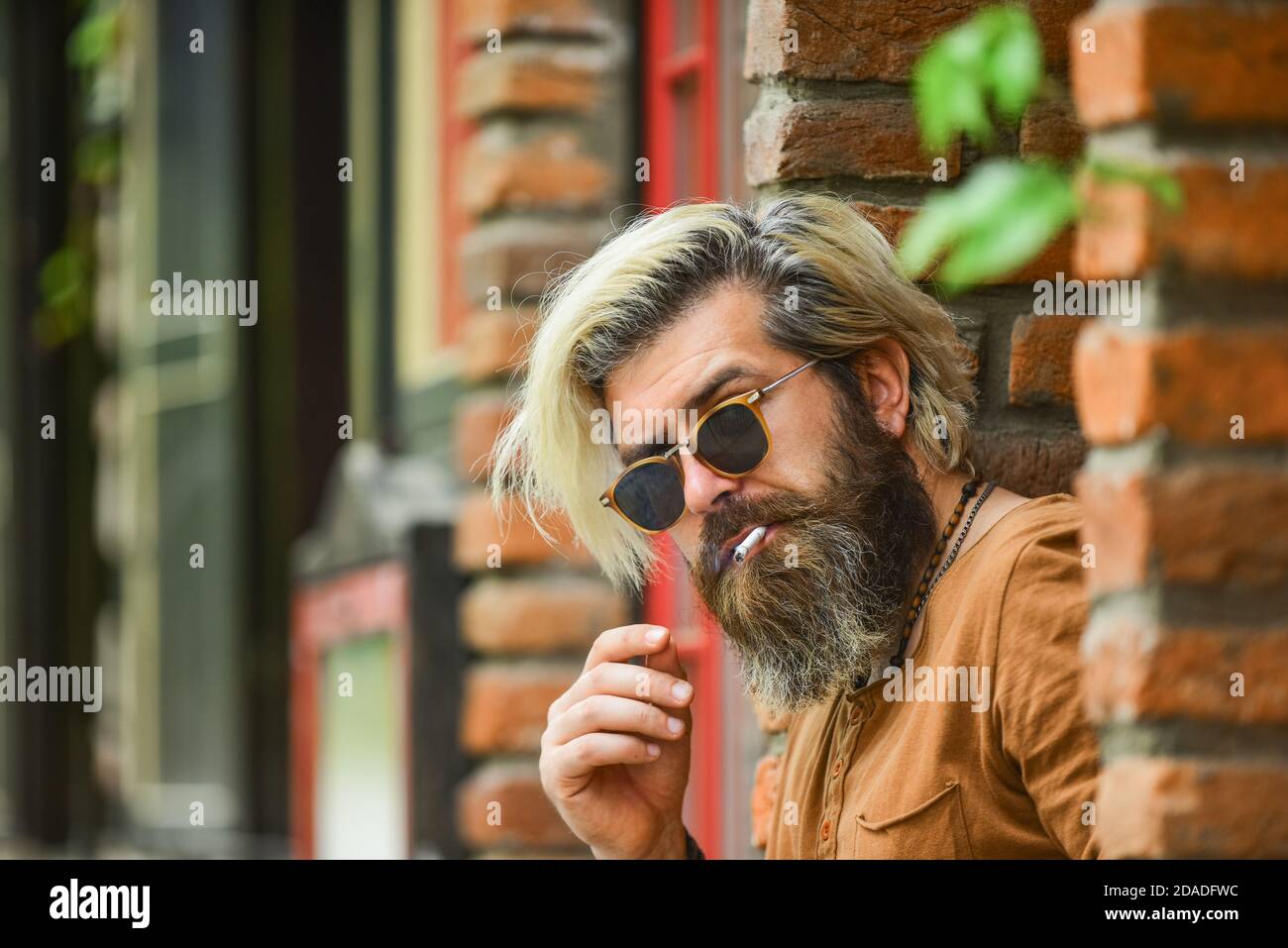 cigarette habit Went on smoke break. Hipster smoking irish pub entrance background. Smoking  habit. Brutal guy sunglasses smoking tobacco. Smoking outdoors. Fashionable  mature man with cigarette. Cool guy relaxing Stock Photo