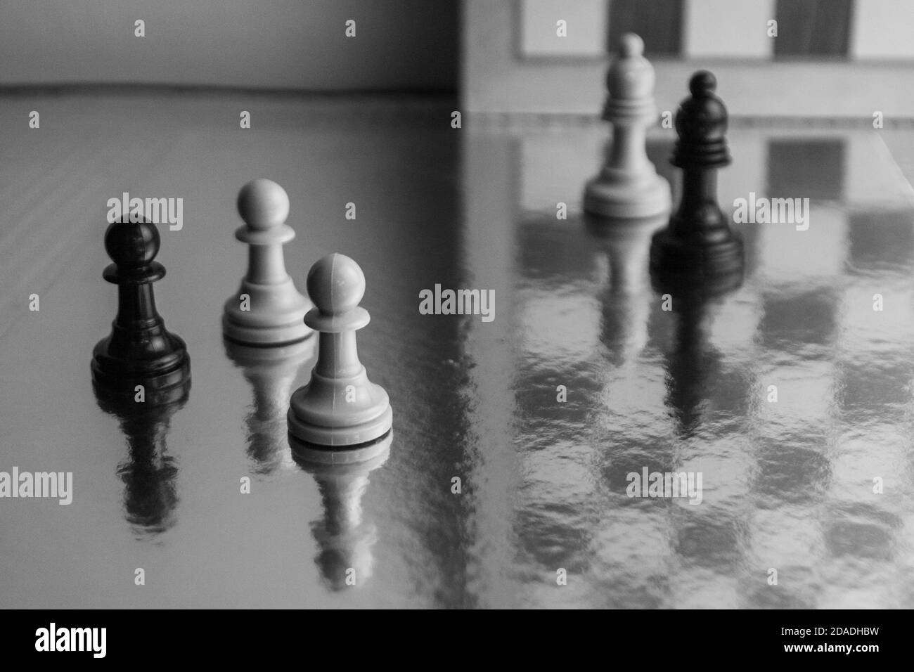 Photograph of black and white chess pieces. Strategy game. Pawns with reflections on original background Stock Photo