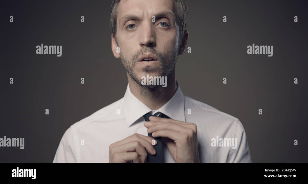 Confident young man adjusting his tie before an important meeting, look and style concept Stock Photo