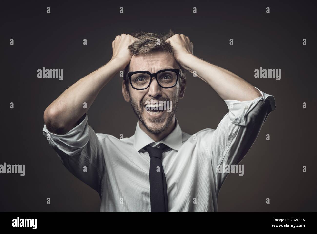 Disappointed businessman with head in hands, he has made a mistake and he is panicking Stock Photo