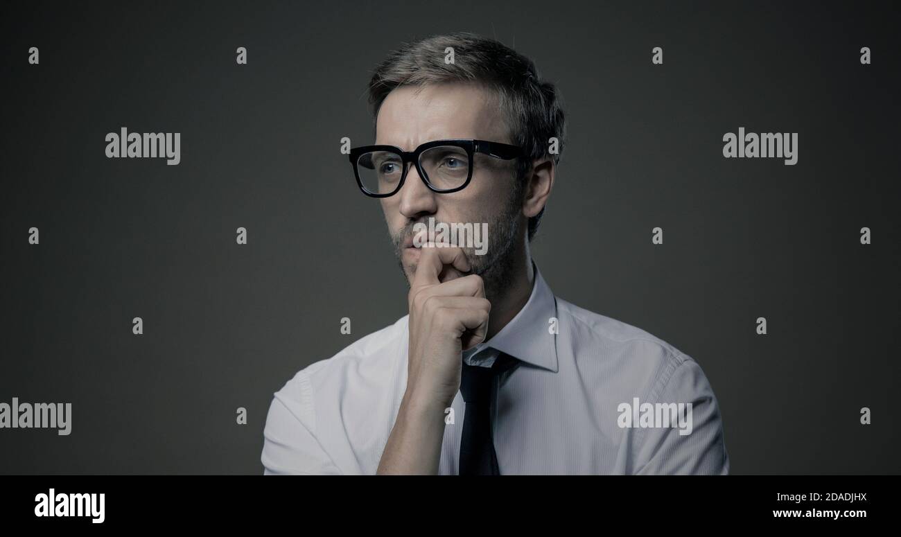 Pensive businessman thinking with hand on chin, problem solving and decisions concept Stock Photo