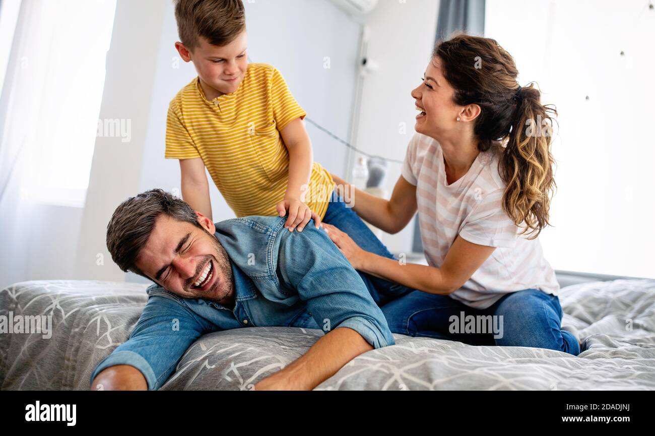 Happy family. Beautiful young parents having fun, playing with their ...