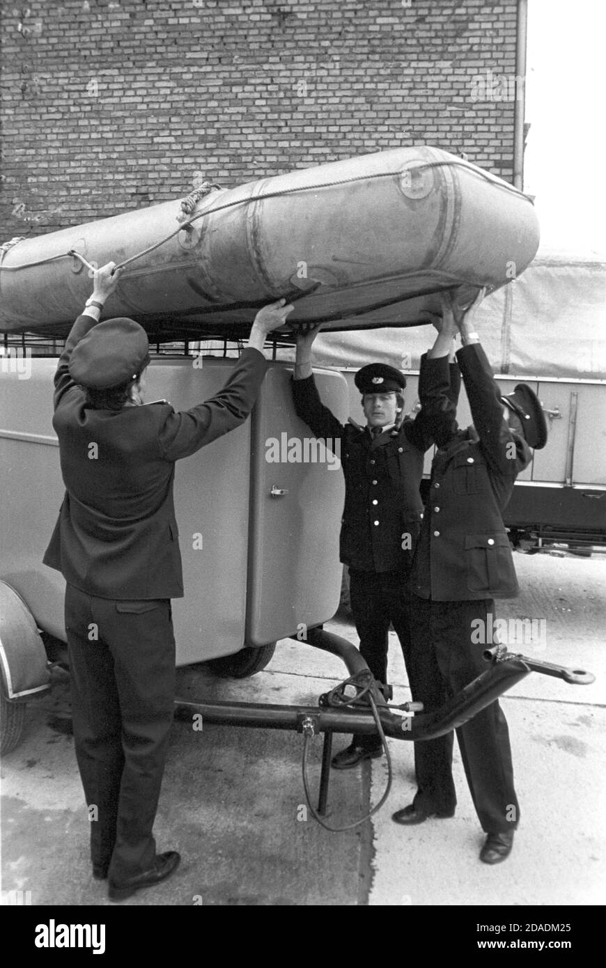 30 November 1983, Saxony, Eilenburg: Comrades of the volunteer fire brigade Eilenburg East lift an inflatable boat from a fire engine car in autumn 1984. The exact date of the lift is not known. Photo: Volkmar Heinz/dpa-Zentralbild/ZB Stock Photo
