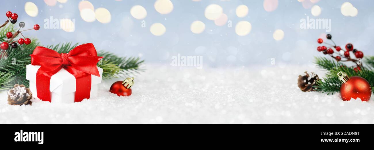 Wide panorama banner design image with festive Christmas decoration ornaments in winter landscape with gift box and decorations Stock Photo