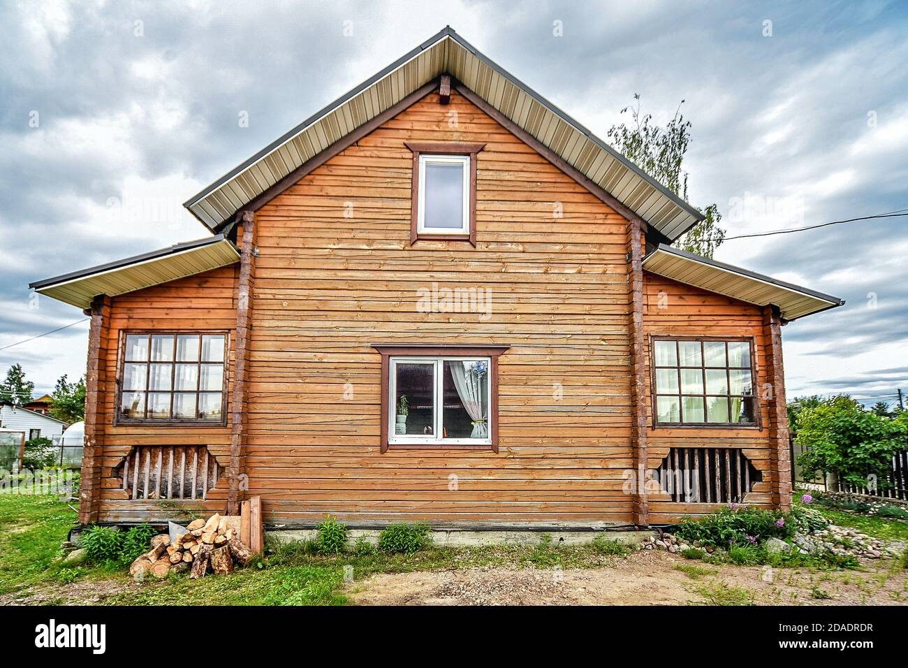 Rustic two-story wooden house, Country life in the summer. Russia Stock Photo