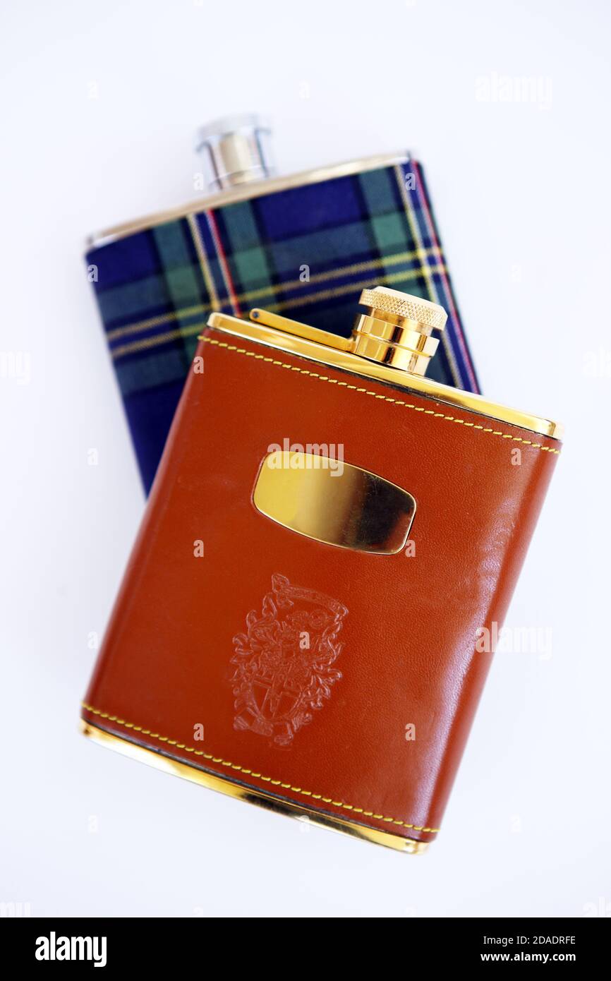 Leather and tartan covered hip flasks on a white background Stock Photo