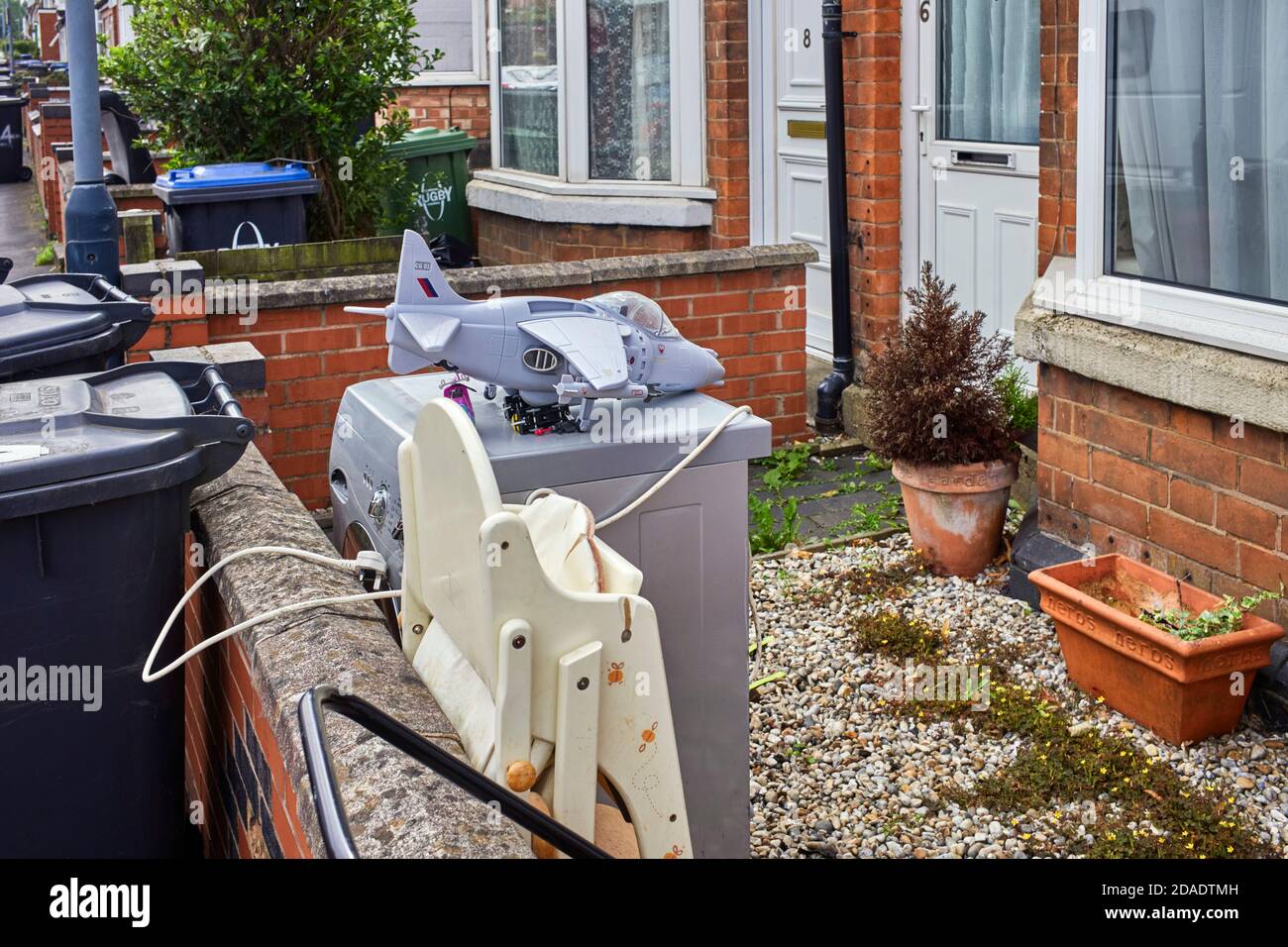 Rubbish including a plastic toy airplane in front garden of a terraced house Stock Photo