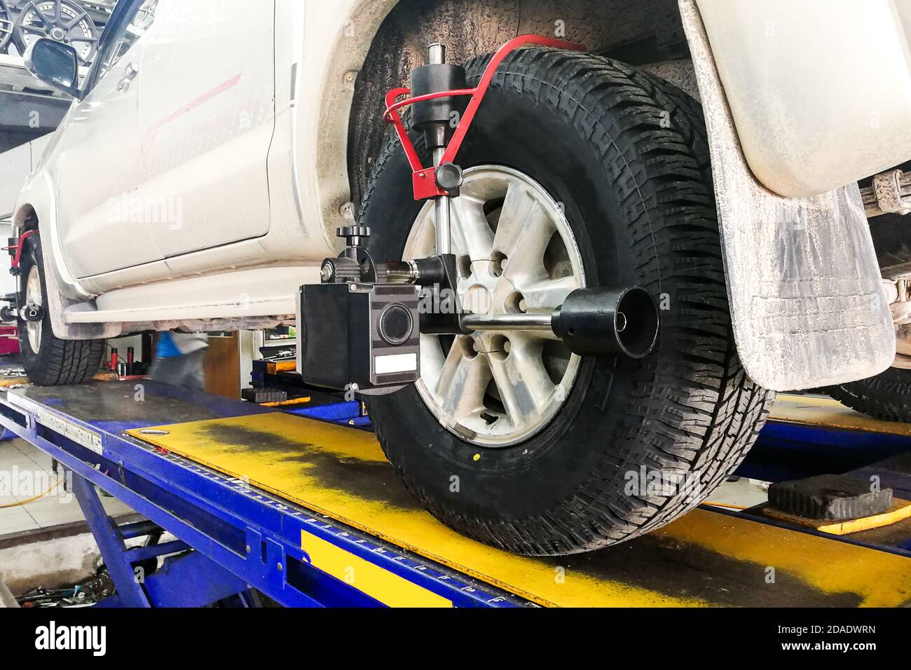 Car undergo wheel align in garage Stock Photo - Alamy