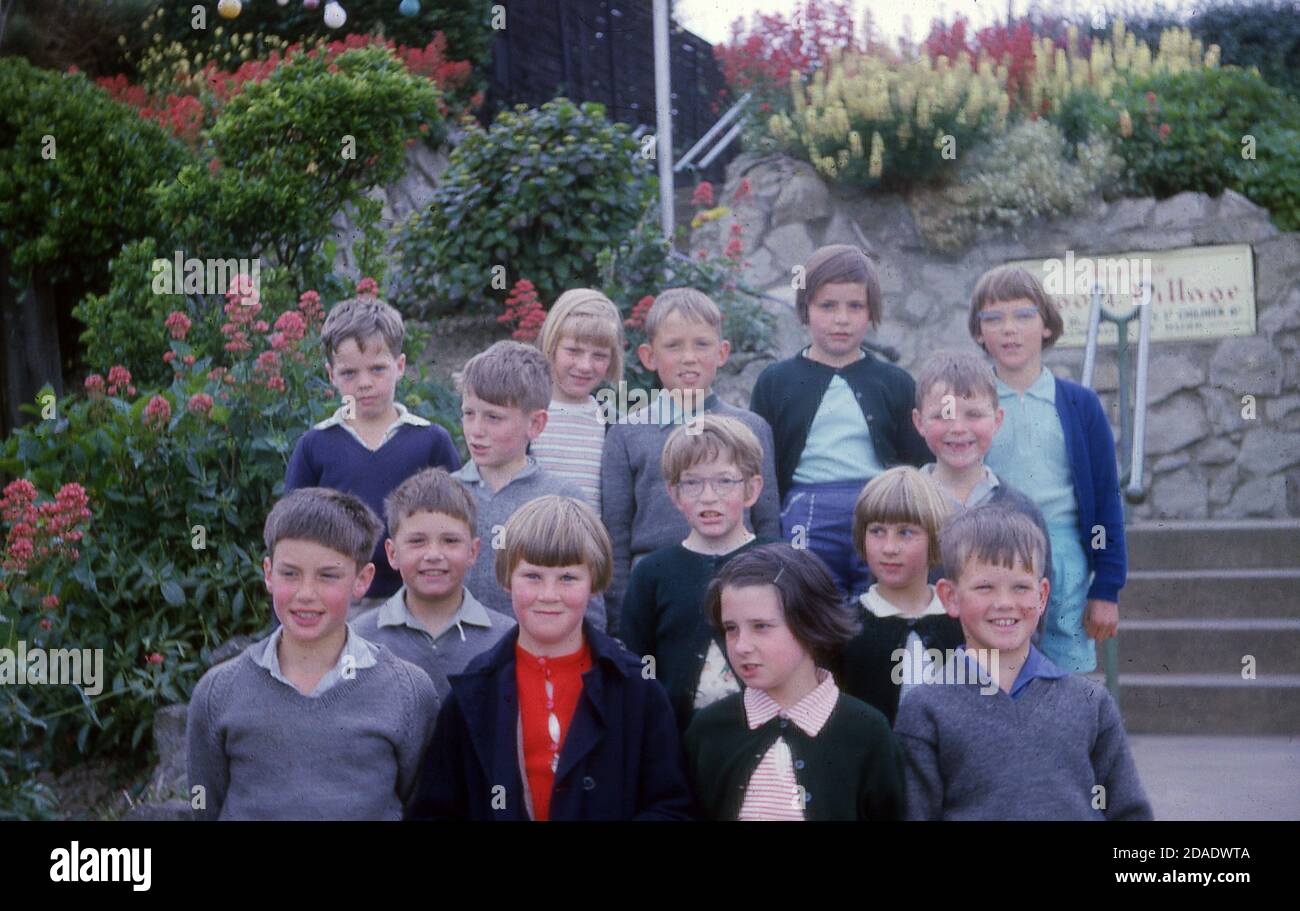 1960s, historical photo of some primary school children standing at the entrance to the Model Village in White Rock Gardens, Hastings, E. Sussex, England, UK. Designed by Stanley Deboo and opened in 1955, the village was constructed by Benjamin White, following the successful village he had bult in Ramsgate. The model village in Hastings was named 'Ganymeade' and featured small scale reproductions of many Sussex buildings. Although popular, it was removed in 1998 due to vandalism issues. Stock Photo