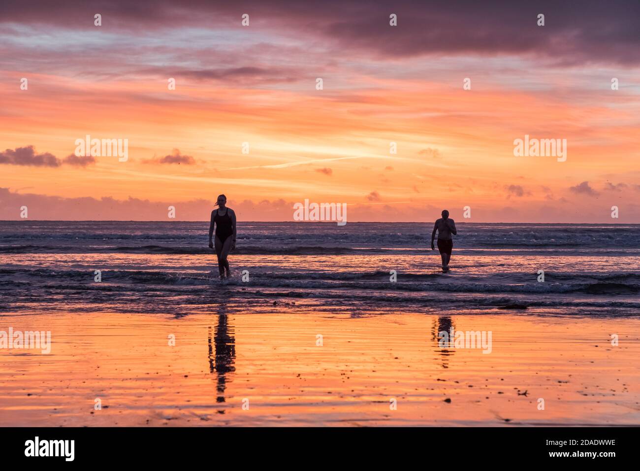 Fountainstown, Cork, Ireland. 12th November, 2020. Danu Ní Thuama and Séamus Ó Thuama emerge from the sea after their  early morning swim under a glorious dawn sky at Fountainstown, Co. Cork, Ireland. - Credit; David Creedon / Alamy Live News Stock Photo