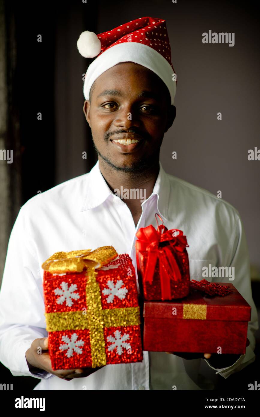 Happy african man giving a christmas gift.Low key style Stock Photo