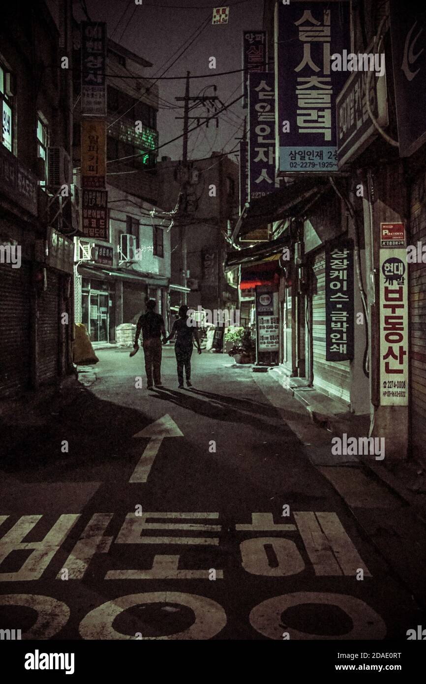 korean couple walking in seoul street at night Stock Photo