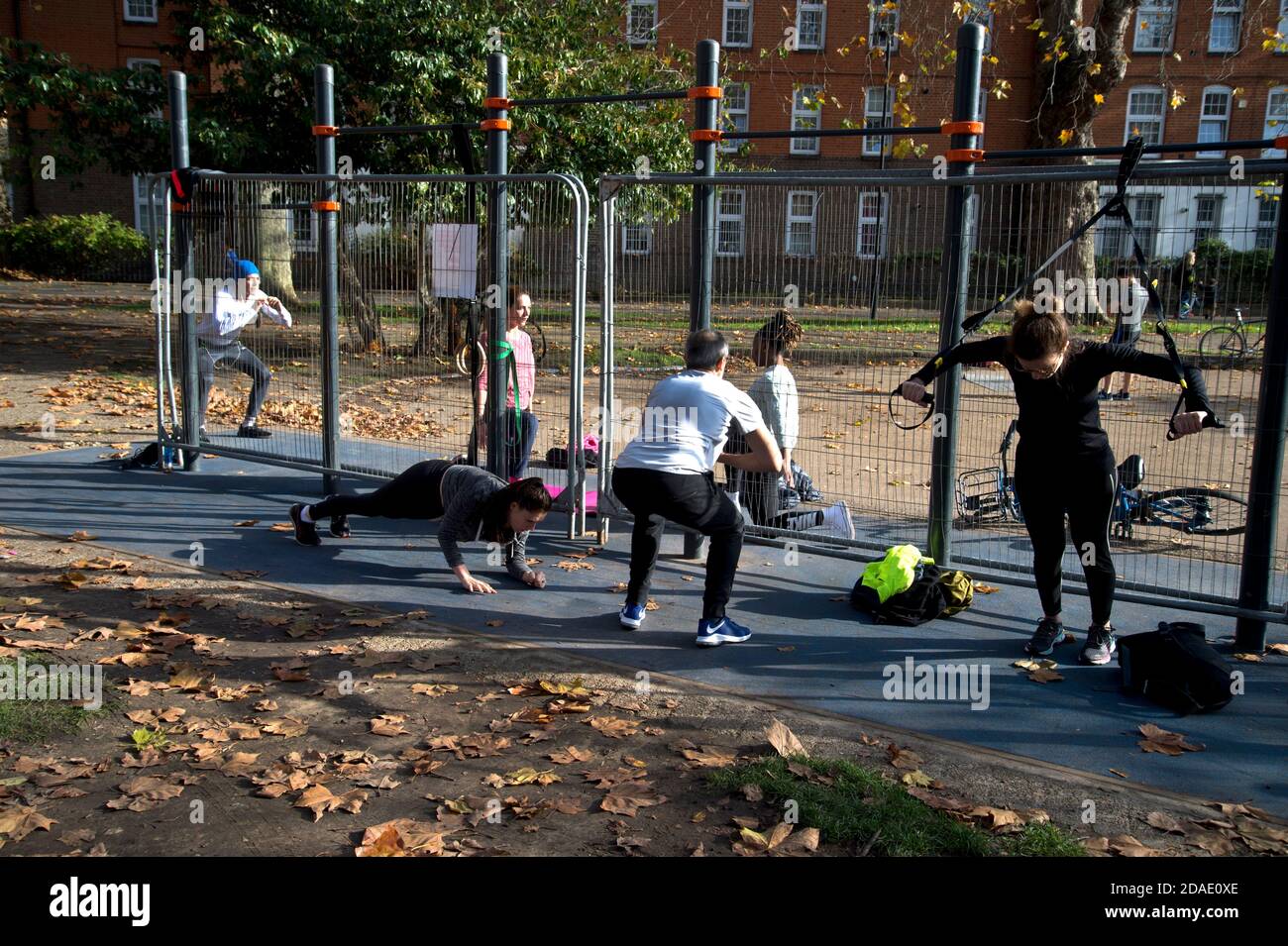London, Hackney. London Fields. People exercise next to locked up gym equipment Stock Photo