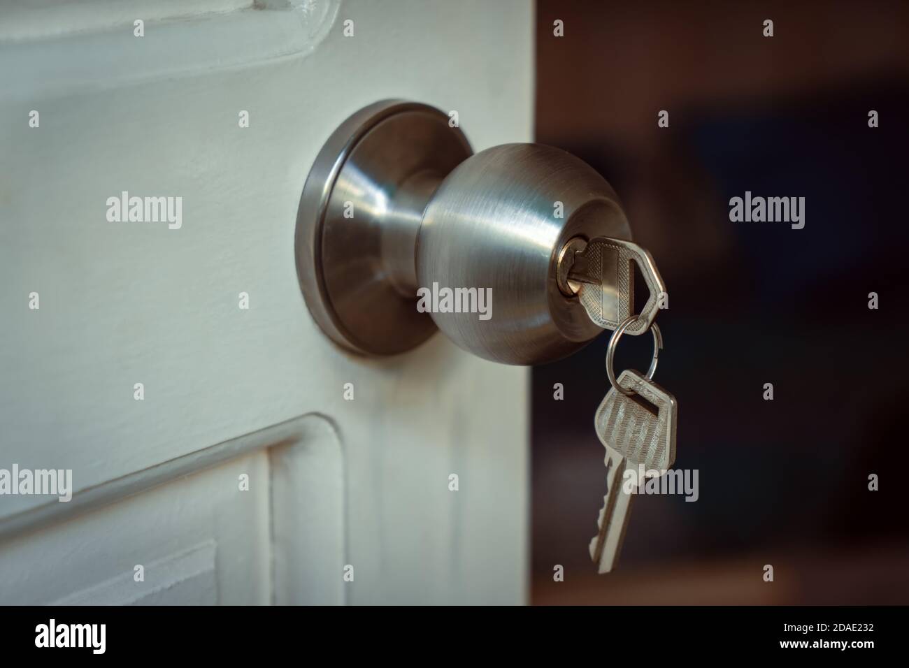 Key put in a knob lock on a white open door Stock Photo Alamy