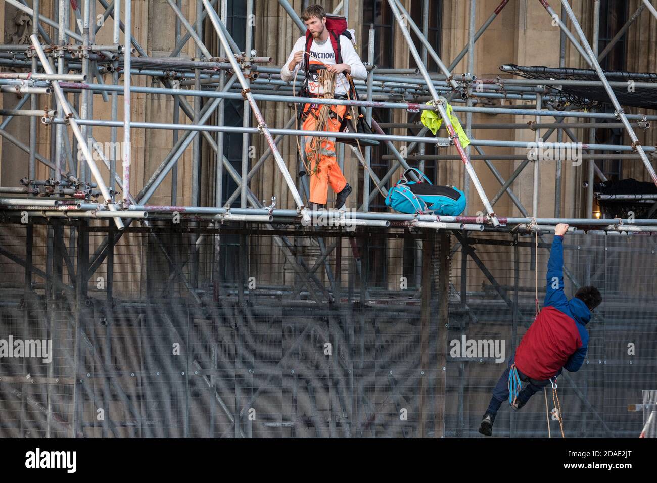 London, UK. 12th November, 2020. Activists from the group Action for Climate Truth and Reparations (ACTR) climb scaffolding to hang an open letter to the UK people from Africans Rising For Justice, Peace and Dignity from the Houses of Parliament. The letter, which launches Africans Rising’s ReRight History campaign, contains a plea to the UK people to start making amends for the harm caused by slavery and colonialism.  Credit: Mark Kerrison/Alamy Live News Stock Photo